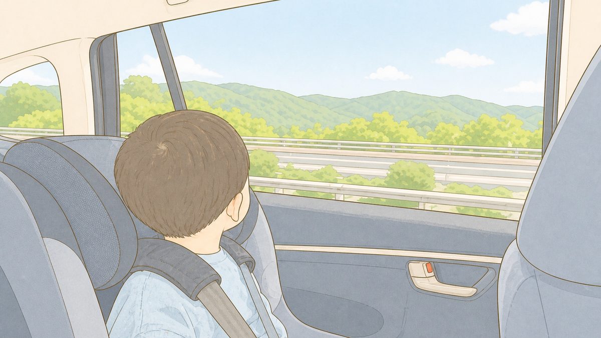 高速道路を走る車の後部座席から外を眺める子ども