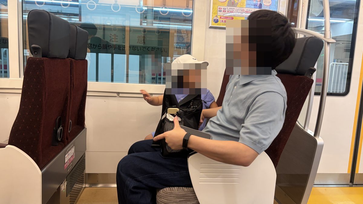 京王ライナーの座席に座る親子