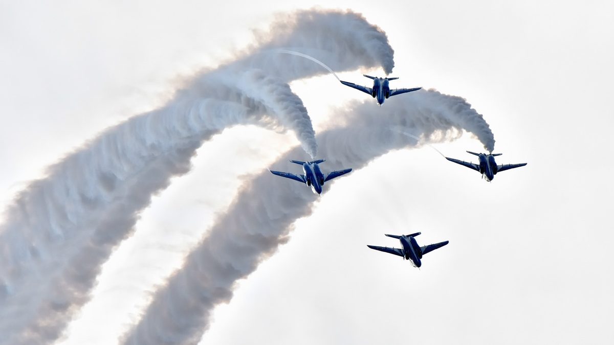 空に大きなカーブのスモークを描くブルーインパルス